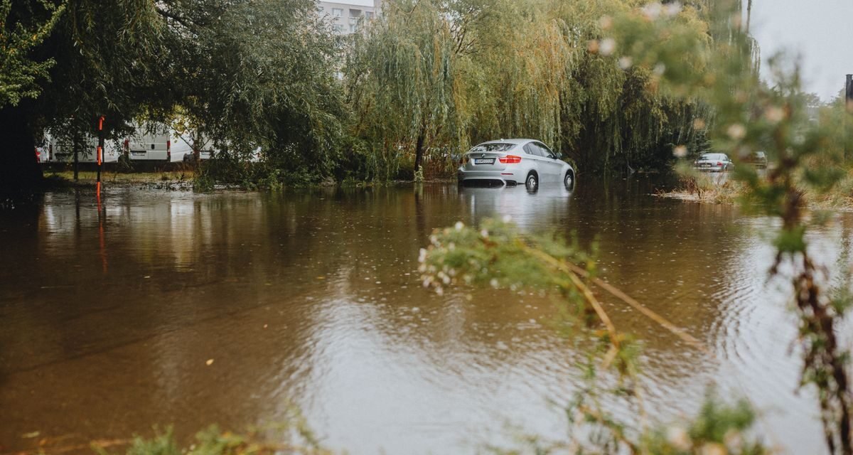 Car navigating a flooded urban street after heavy rain in the UAE