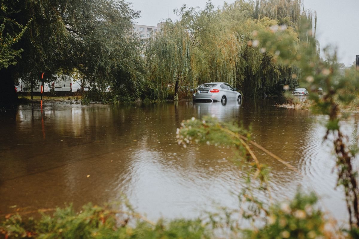 Car navigating a flooded urban street after heavy rain in the UAE