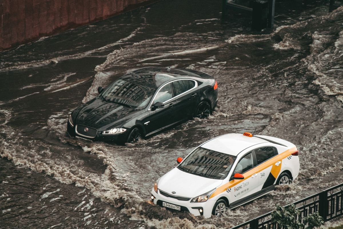 Car parked in a flooded street with water reaching the wheels