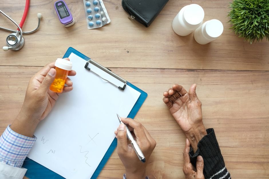 Doctor reviewing medicines with an elderly patient – pre-existing conditions cover