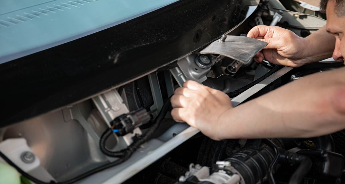 Mechanic repairing a car in a garage, representing agency vs non-agency repair
