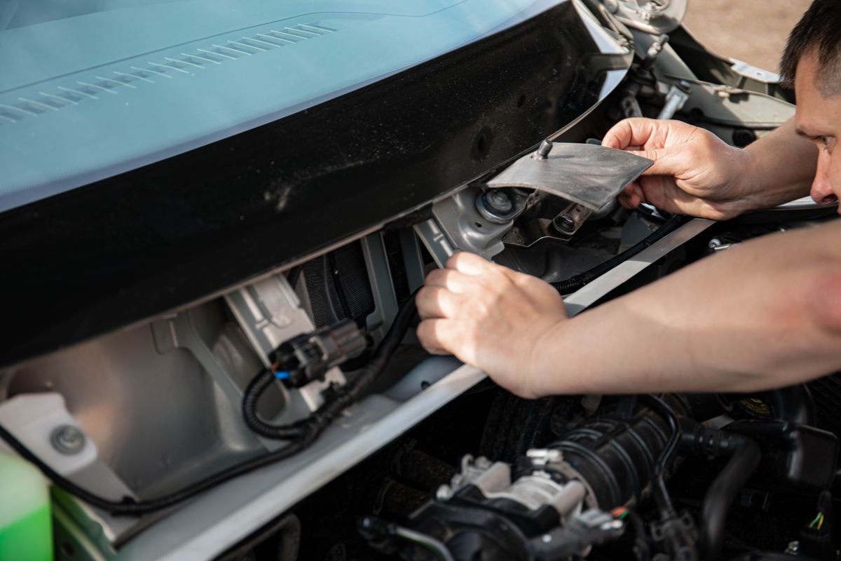 Mechanic repairing a car in a garage, representing agency vs non-agency repair
