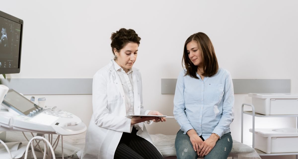 Pregnant woman consulting a gynecologist, representing maternity insurance in the UAE
